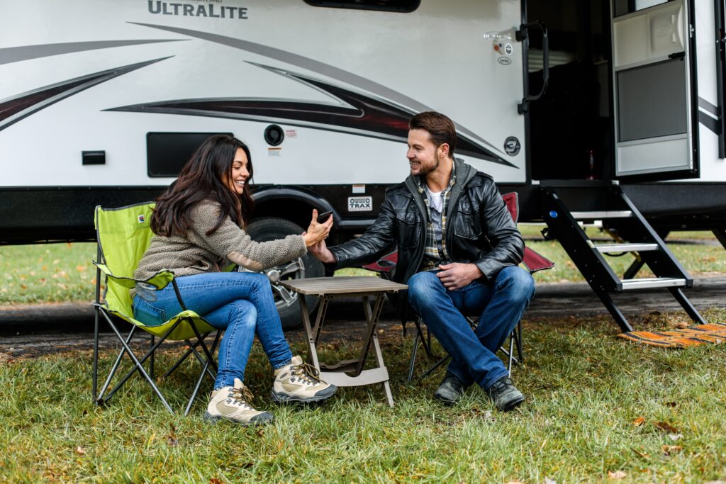 couple sitting under retractable rv awning